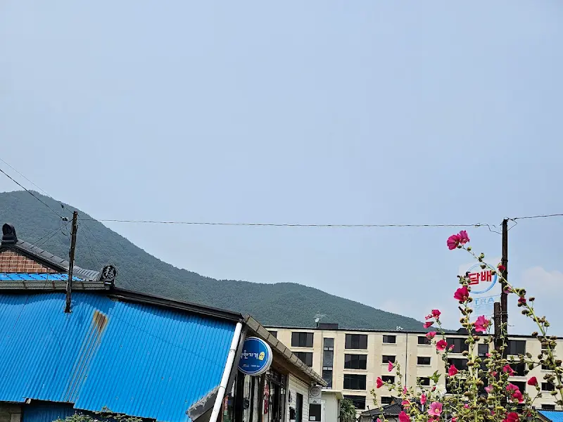 푸른 기와지붕과 하늘이 어우러진 번영슈퍼 외경