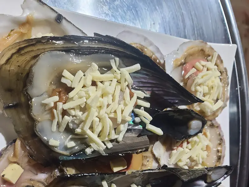 싱싱한 조개 위에 듬뿍 뿌려진 치즈