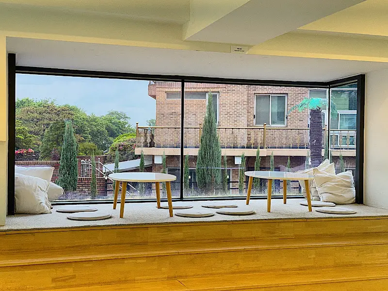 창가 좌석에 앉아 쿠션을 베고 휴식을 취하는 모습