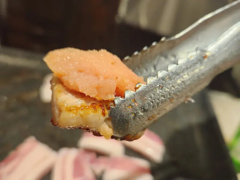 집게로 삼겹살과 명란을 함께 집은 모습