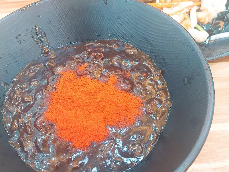 짜장면 위에 고춧가루가 뿌려진 모습