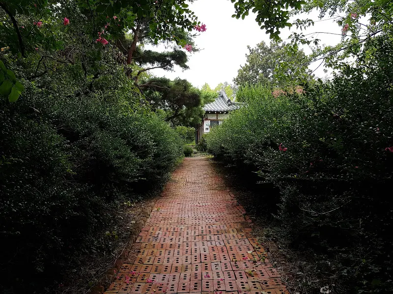 붉은 벽돌길과 푸른 나무가 어우러진 춘향골의 정원