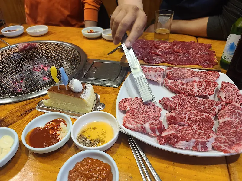 테이블에 놓인 잘 구워진 소고기와 다양한 소스들