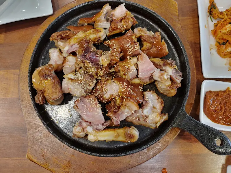 철판 위에 윤기가 흐르는 족발이 담겨 있는 모습