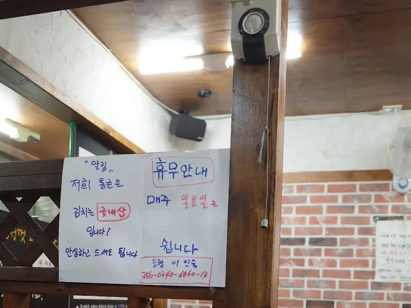 나무 격자 칸막이 위에 붙어있는 안내문