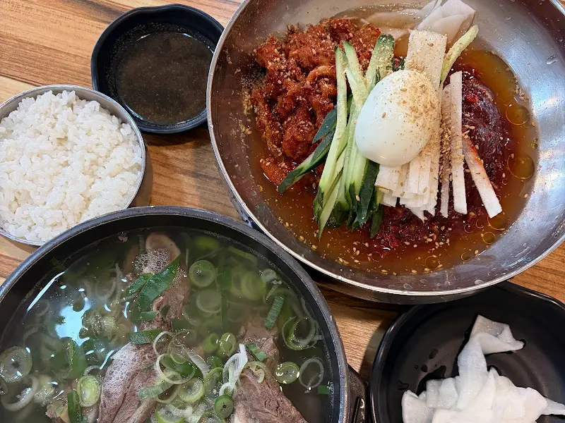 코다리 냉면, 갈비탕, 만두가 차려진 테이블