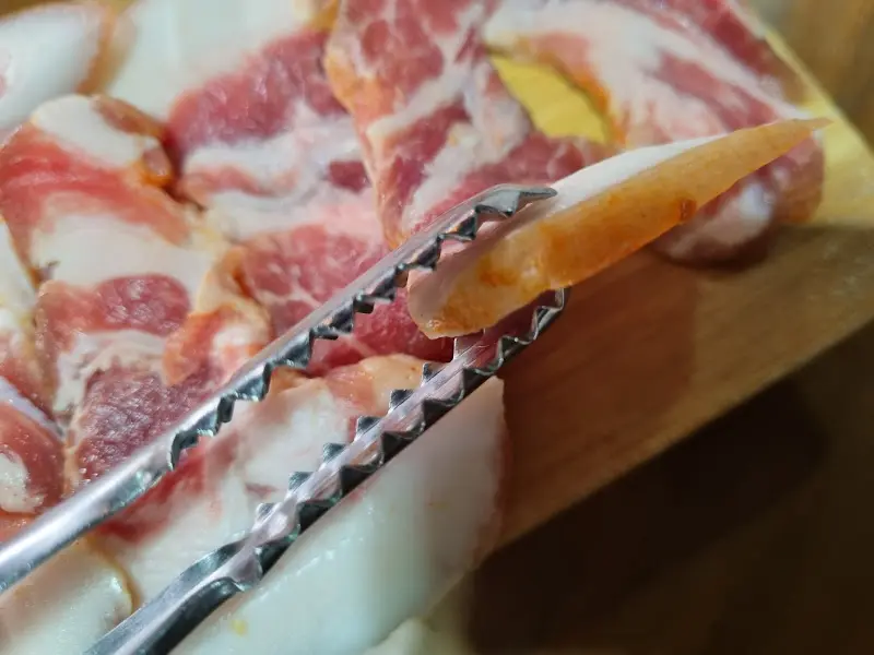 집게로 고기를 들어올리는 모습