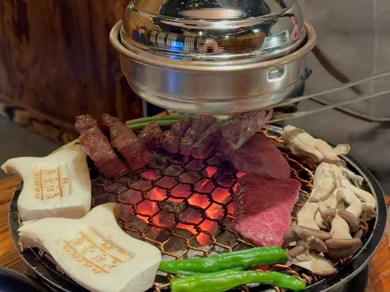 불판에 구워지는 소고기, 버섯, 채소