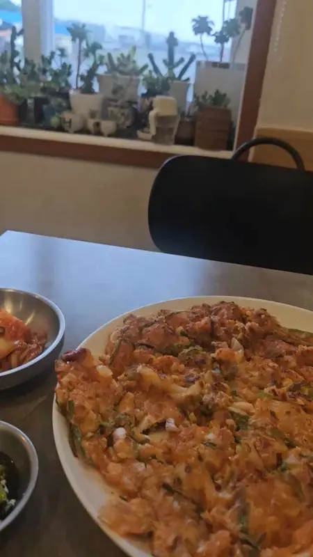 테이블 위에 놓인 김치전과 김치, 깍두기