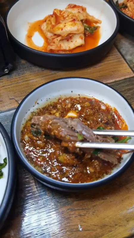 흑염소 고기를 특제 소스에 찍어먹는 모습