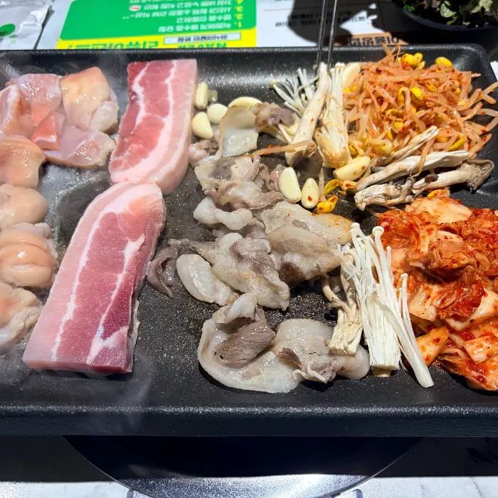 다양한 종류의 고기와 곁들임 메뉴가 준비된 불판