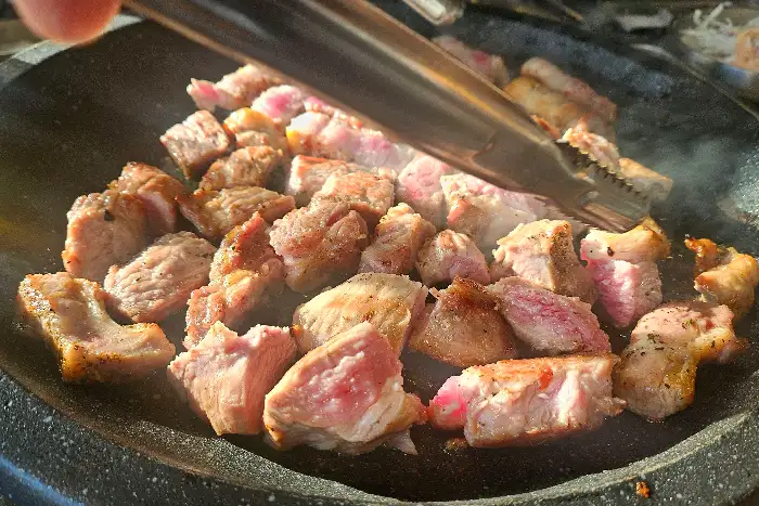 초벌된 돼지고기가 불판에서 구워지고 있습니다.