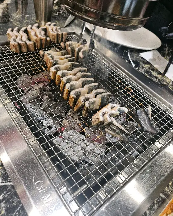 여러 개의 장어 토막이 불판 위에 놓여 있는 모습