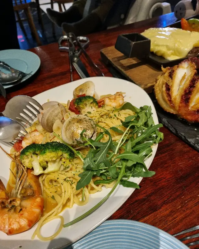 문어 파스타의 전체적인 모습, 큼지막한 문어와 파스타면, 브로콜리, 채소가 함께 보인다.