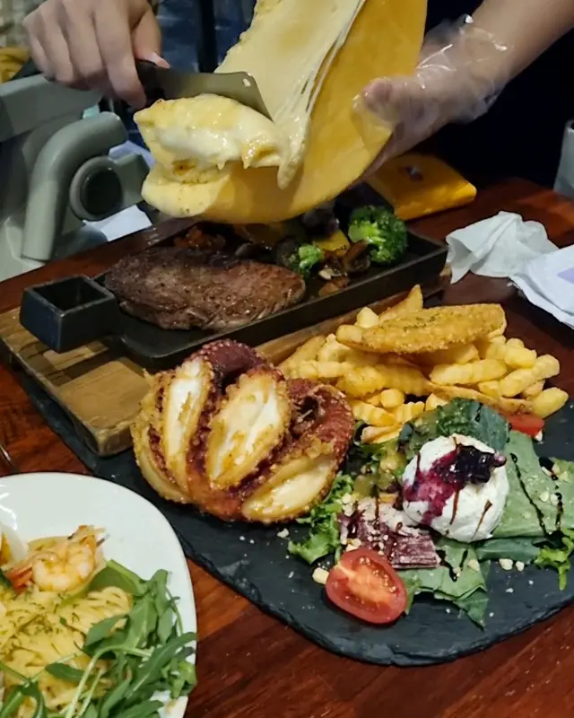 라끌렛 치즈가 등심 스테이크 위로 흘러내리는 모습