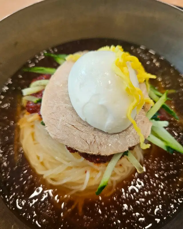 먹음직스럽게 고명이 올라간 명가밀면