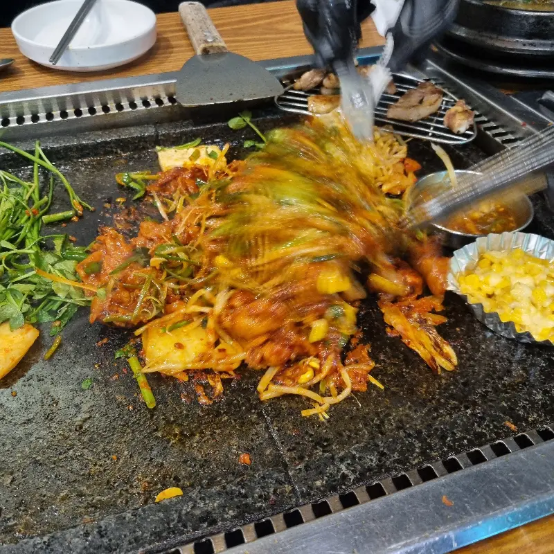 돌판 위 삼겹살과 야채들