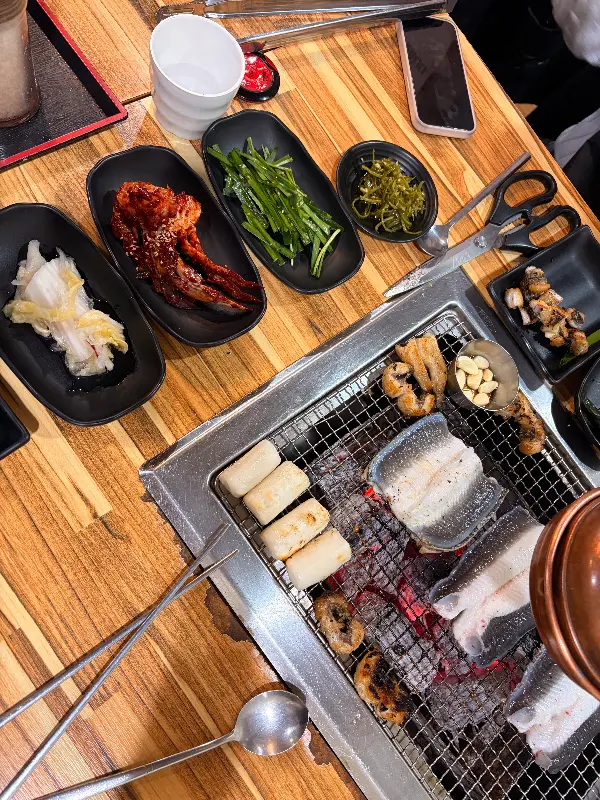 숯불 위에 구워지는 장어와 밑반찬