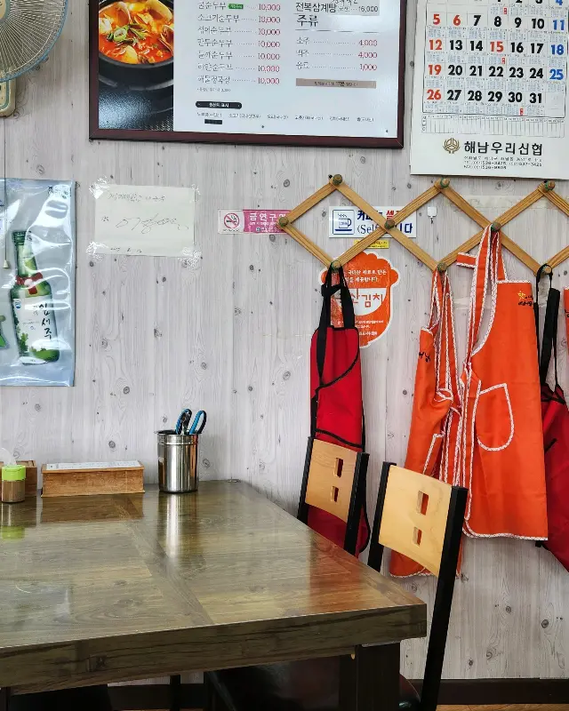벽에 걸린 메뉴판과 앞치마가 걸려있는 모습