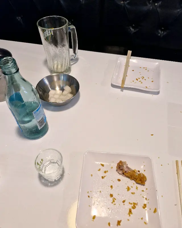 테이블 위에 놓인 닭 뼈와 콜라, 치킨 무