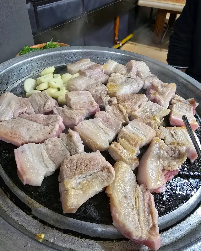 불판 위에 삼겹살과 함께 구워지는 마늘