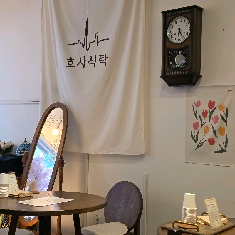 벽에 걸린 '호사식탁' 간판과 앤티크한 시계