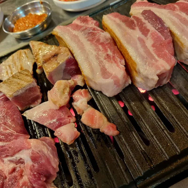 연탄불에 구워지고 있는 삼겹살과 꼬들살