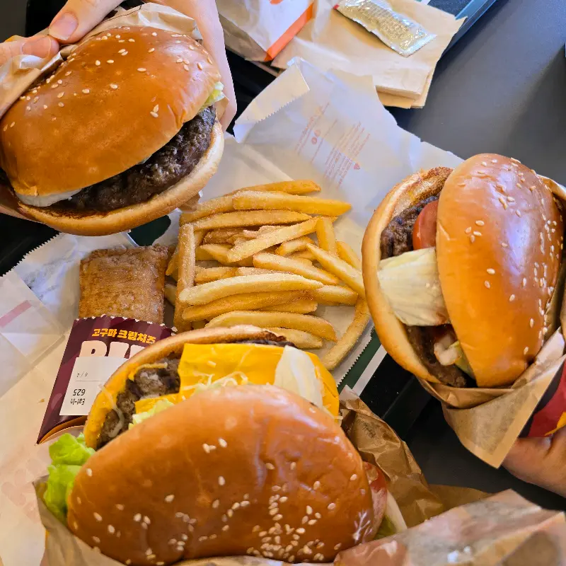 테이블 위에 놓인 와퍼, 고구마파이, 감자튀김