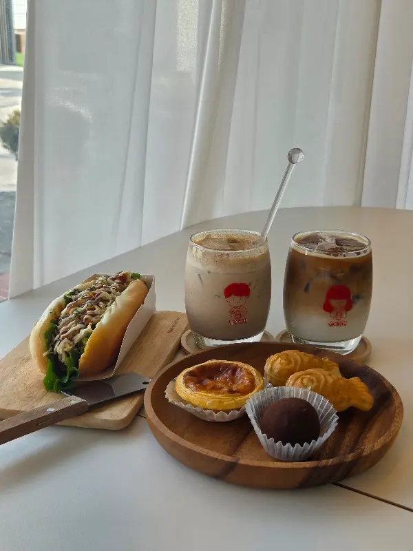 테이블 위에 놓인 핫도그, 음료, 디저트