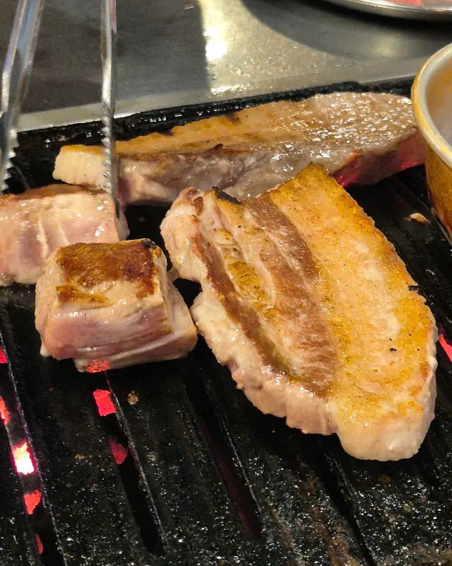 연탄불 위에서 노릇하게 익어가는 삼겹살