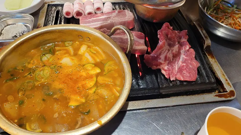 불판 위에 올려진 다양한 종류의 고기와 찌개