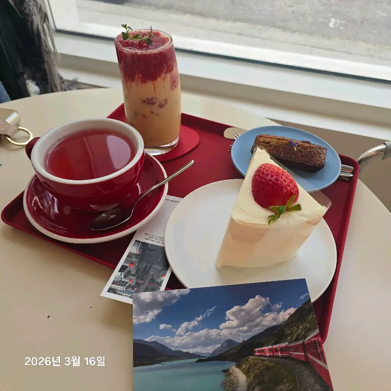 딸기 케이크와 음료가 함께 놓여진 테이블