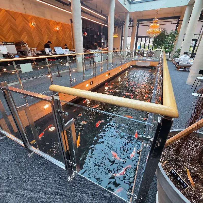 카페 내부 전경: 거대한 잉어 연못과 높은 천장이 인상적이다.