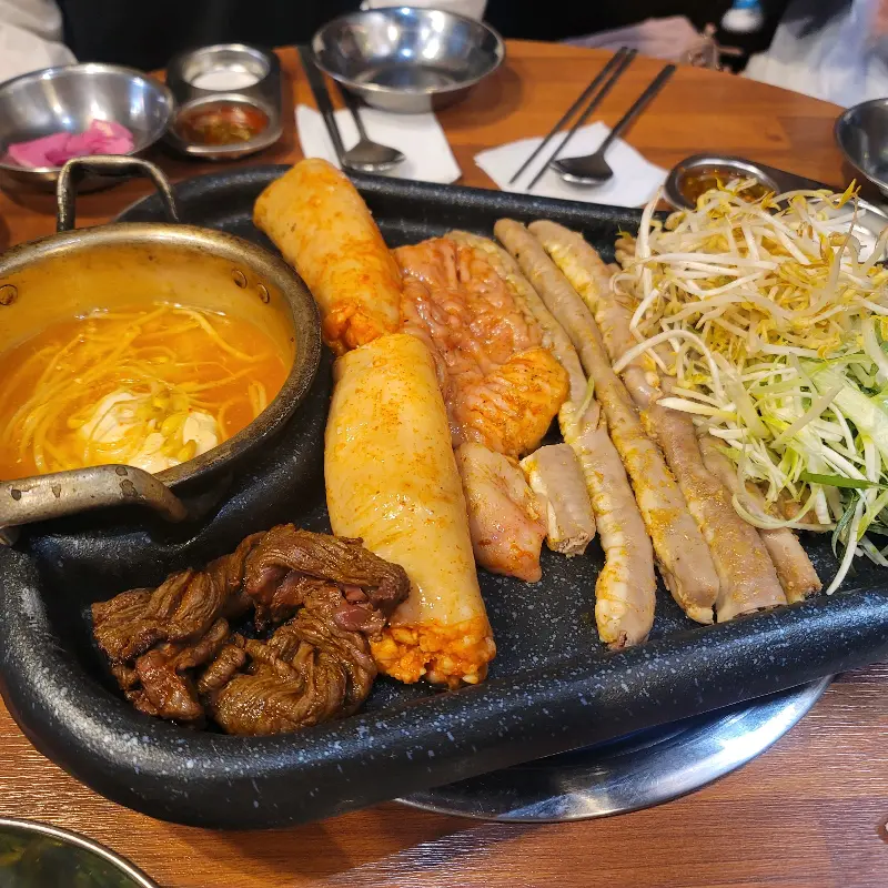 잘 구워진 곱창을 소스에 찍어 먹는 모습