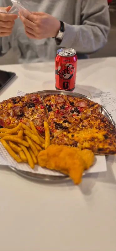 피자와 감자튀김, 콜라가 놓여있는 테이블 전경