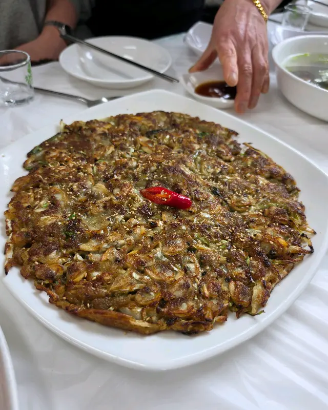 커다란 메밀 바지락전, 겉은 바삭하고 속은 촉촉해 보인다.