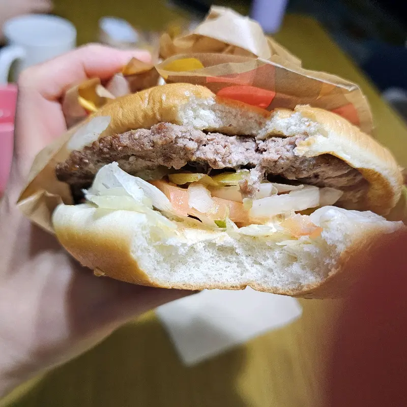 손으로 잡고 있는 와퍼 햄버거의 단면