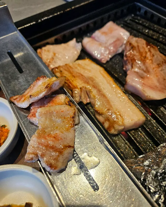 불판 위에서 윤기 자르르 흐르는 삼겹살