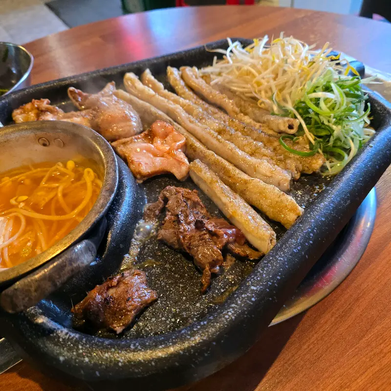 불판 위에 곱창과 대창, 안창살, 콩나물국이 함께 놓여있는 모습