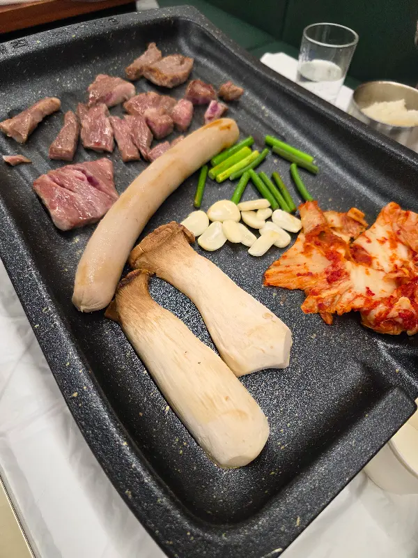 불판 위에서 조화롭게 구워지는 냉삼과 김치