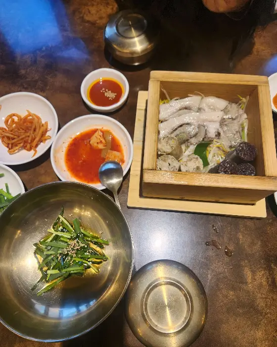 오징어볶음, 순대국, 밥, 부추 등이 담긴 식탁