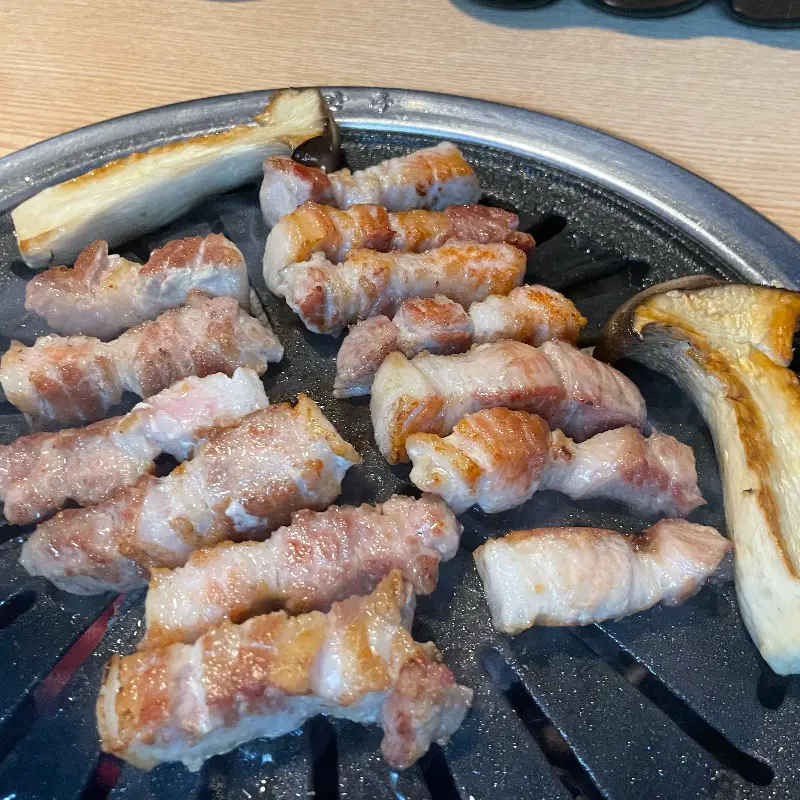 잘 구워진 삼겹살과 곁들임 버섯