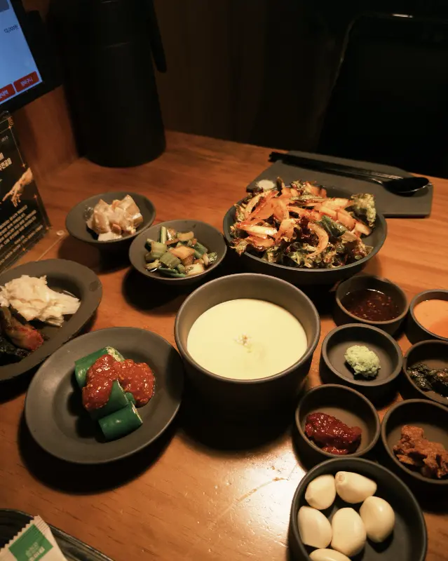 다양한 밑반찬이 정갈하게 담겨 테이블 위에 놓여있다.