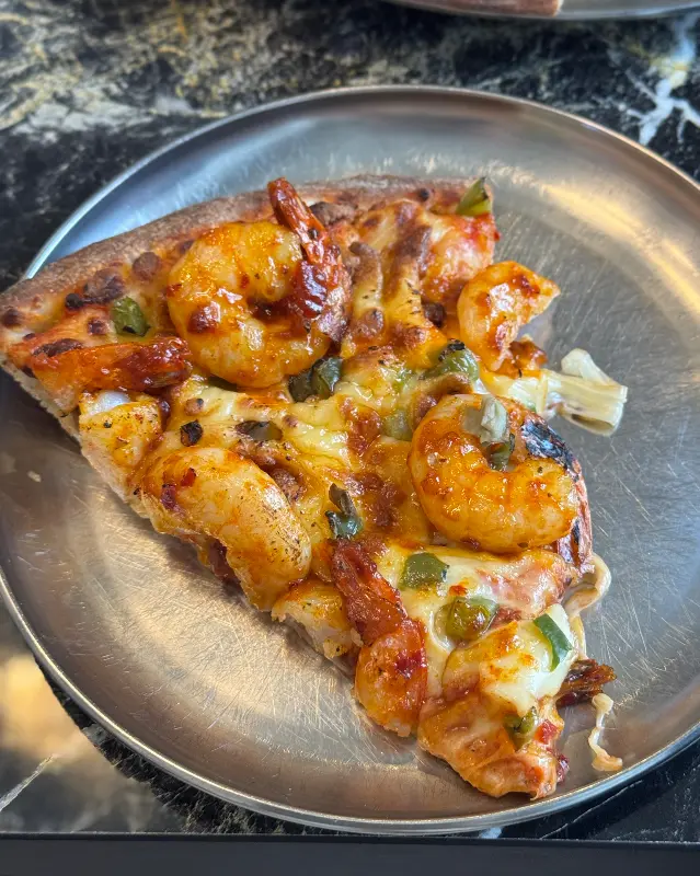 싱싱한 재료가 듬뿍 올라간 피자 한 조각