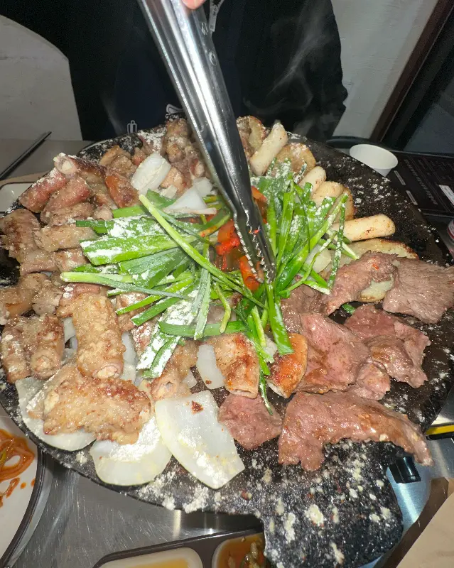 마늘 곱창을 집게로 들어올리는 모습