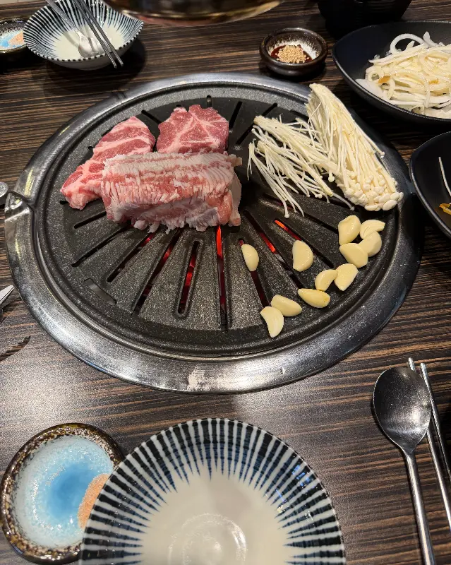 숯불 위에 고기와 마늘을 함께 구워 먹는 모습