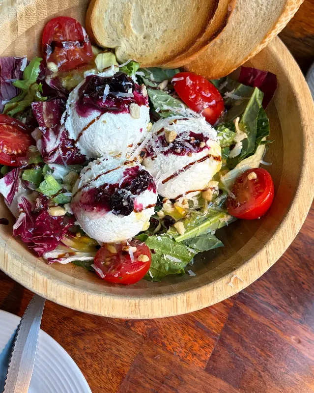 브라타 치즈 샐러드의 클로즈업 샷, 신선한 채소와 브라타 치즈가 보인다.