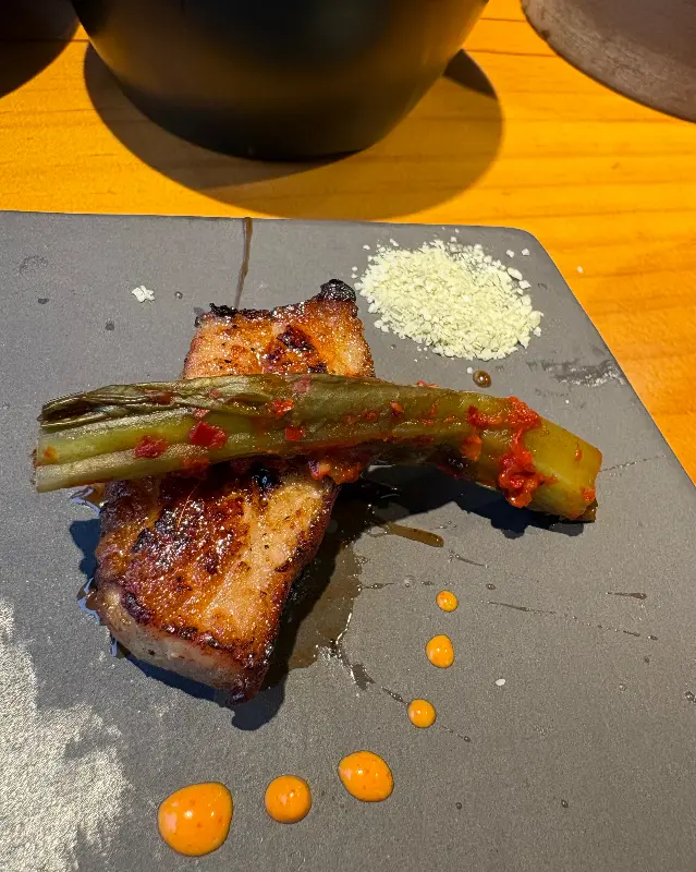 구운 고기 한 점과 꽈리꼬추가 접시에 담겨있다.