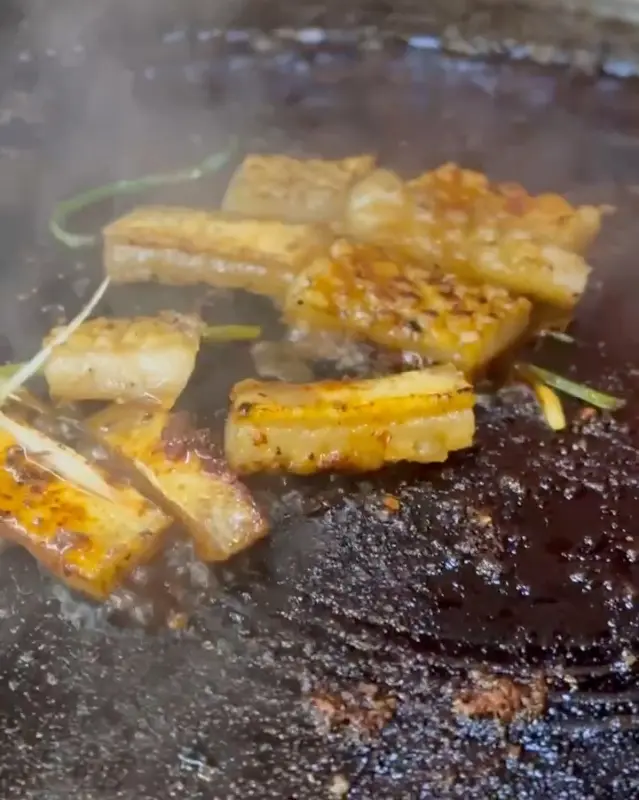 불판 위에서 노릇하게 구워지고 있는 흑돼지 껍데기