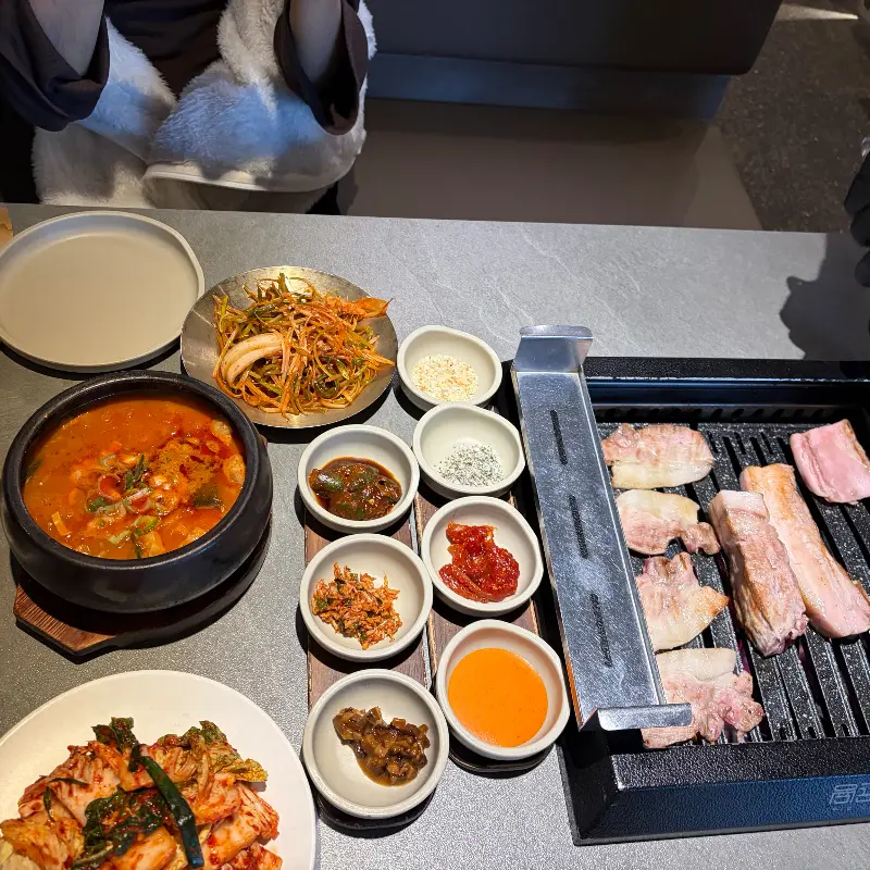 맛있게 구워진 고기 한 점을 젓가락으로 집어 올리는 모습